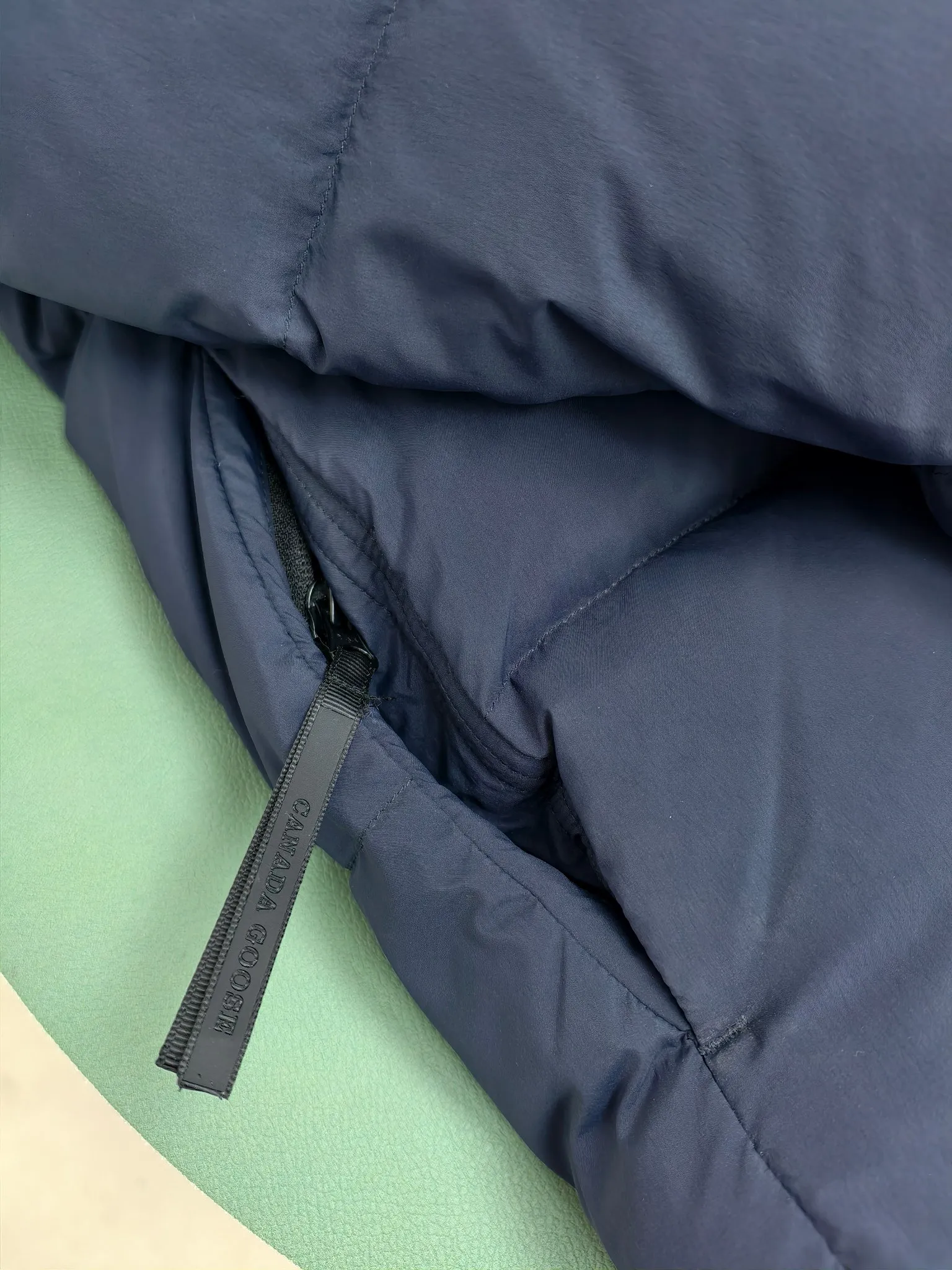 P940 Canada Goose Lawrence Down Jacket The Lawrence Down Jacket provides essential protection for everyday adventures and is made from sustainable Enduraluxe fabric with a durable soft touch. It features a quilted body, an adjustable down hood and a longer hem. Adjustable, down-filled, communicated hood. Two-way center front zipper increases range of motion and ventilation. The chin-protecting suede knit stand-up collar is soft and extra-comfortable. Inset rib-knit cuffs for added comfort and locked in heat. CORDURAD piping at the cuffs hem and reflective double-stripe grip tape at the back. Internal shoulder strap Color: black with red label black with black label azure blue Size: XS-2XL